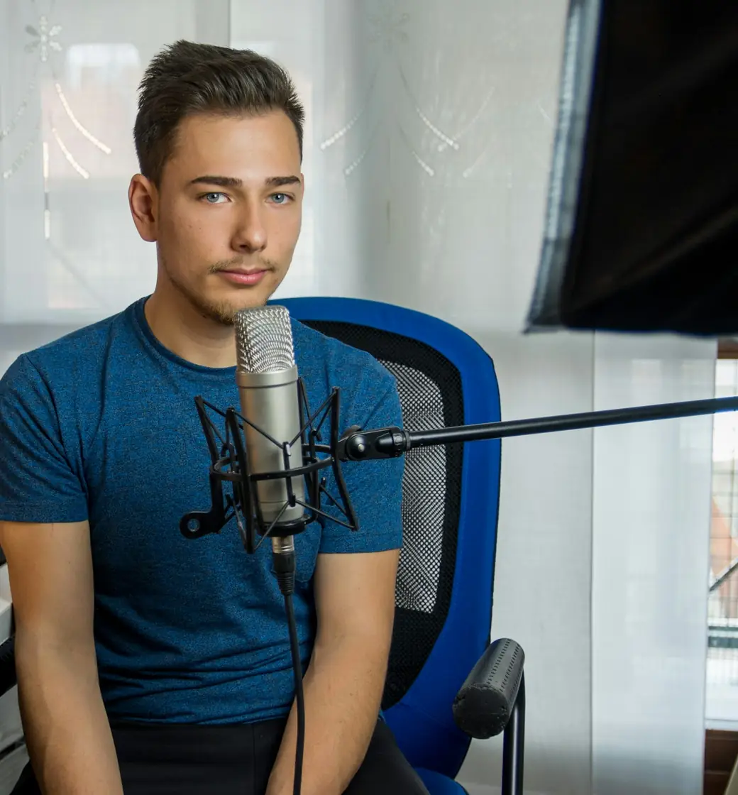 YouTuber at a studio microphone recording a video announcement